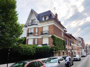 a building with cars parked on the side of a street at La Romantique in Paris