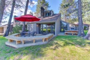 a house with a patio with a table and a red umbrella at Meadow House 30 | Discover Sunriver in Sunriver