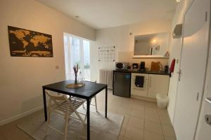 a kitchen with a black table and a kitchen with a stove at Studio with terrace in 17th century house in Bruges