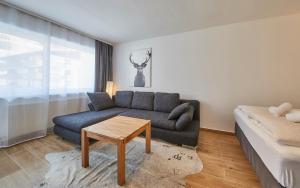 a living room with a couch and a table at Appartement Timeout in Saalbach-Hinterglemm