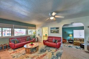 a living room with red furniture and a ceiling fan at Vintage Las Vegas Oasis Less Than 3 Miles to the Strip! in Las Vegas