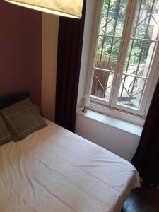 1 dormitorio con cama blanca y ventana en Appartement Petite France avec terrasse, en Estrasburgo