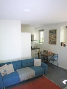 Sofá azul en la sala de estar con mesa en Appartement Petite France avec terrasse en Estrasburgo