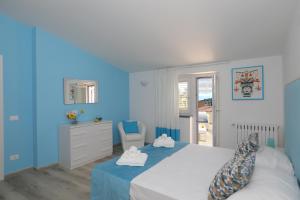 ソレントにあるRelais Villa Chiara free parkingの青いベッドルーム(ベッド1台、椅子付)