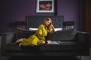 a woman sitting on a couch reading a magazine at Midlands Park Hotel in Portlaoise