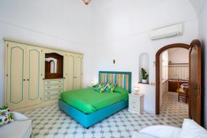 sypialnia z zielonym łóżkiem w pokoju w obiekcie Casa Leucosia, Positano centro w mieście Positano