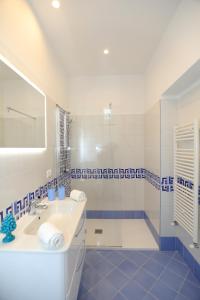 uma casa de banho azul e branca com um lavatório e um chuveiro em Relais Villa Chiara free parking em Sorrento