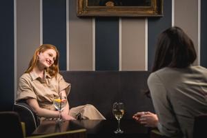 a woman sitting at a table with a glass of wine at Midlands Park Hotel in Portlaoise