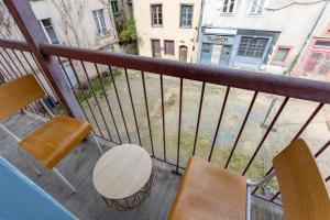 a balcony with two chairs and a table and a street at LE JACOBIN in Rennes