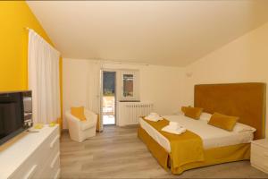 ein Schlafzimmer mit einem Bett, einem TV und einem Sofa in der Unterkunft Relais Villa Chiara free parking in Sorrent