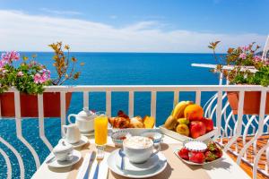 un tavolo con vassoio di frutta su un balcone con vista sull'oceano di Donna Giulia ad Amalfi