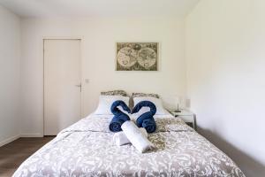 - une chambre avec un lit et 2 serviettes bleues et blanches dans l'établissement LE FOUGERES, à Rennes