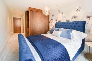 a blue bed in a bedroom with a blue headboard at The Old Fire Station Luxury Apartment in York