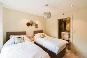 a bedroom with two beds and a mirror at The Old Fire Station Luxury Apartment in York