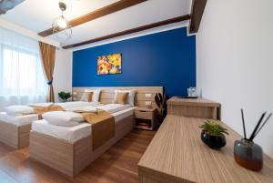 1 dormitorio con 2 camas y pared azul en Escala Rooms, en Ghimbav