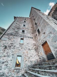 an old stone building with stairs and windows at Hotel Restaurant Stockalperturm in Ruden