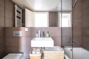 Un baño con lavabo, espejo y bañera. en Apartamento en Port Marina Palamos, en Palamós 11 fotos más