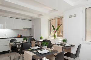 une salle à manger avec tables et chaises et une cuisine dans l'établissement DVE Suite Rome, à Rome