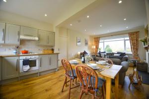 Orchard Cottage في Cornhill-on-tweed: مطبخ وغرفة معيشة مع طاولة وكراسي