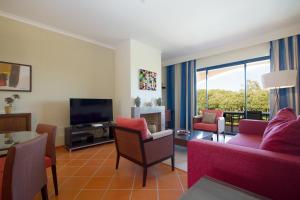 ein Wohnzimmer mit einem Sofa und einem TV in der Unterkunft AL - Apartamento Vila Sol F5 T in Quarteira