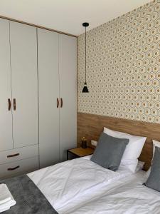 オシフィエンチムにあるApartamenty Parkowe B5のベッドルーム(白いベッド1台、白いキャビネット付)