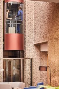 a person standing on a balcony with a suitcase in a building at Silken Puerta Madrid in Madrid