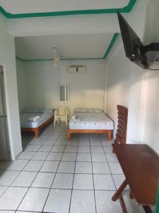 una camera con due letti e una tv di Hotel Gamito a Puerto Escondido