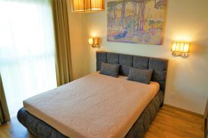 a bedroom with a bed with two pillows on it at Smėlio Vila Apartments in Palanga