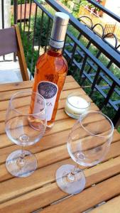 een fles alcohol en twee wijnglazen op een tafel bij Cabà Holiday Bardolino Colombo in Bardolino