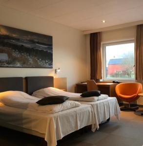 a hotel room with two beds and a window at Havila Hotel Ivar Aasen in &Oslash;rsta