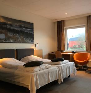 a hotel room with two beds and a window at Havila Hotel Ivar Aasen in Ørsta