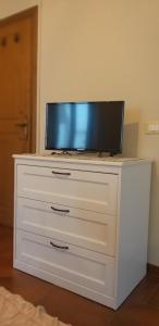 a white dresser with a tv on top of it at A Collodi Io & Mamma 100 m dal Parco di Pinocchio in Collodi