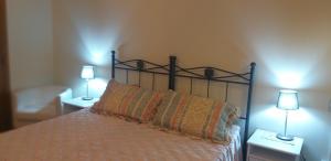 een slaapkamer met een bed met twee lampen op twee tafels bij A Collodi Io & Mamma in Collodi