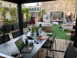 a desk with a laptop on top of a patio at BEAUTIFUL PLACE WITH BREATHTAKING PRIVATE ROOFTOP TERRACE 210m2 IN CITY OF LOVE PARIS in Paris