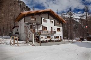 a large building in the snow in front of a mountain at B&B La Locanda in Macugnaga
