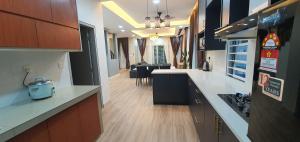 a kitchen with white counter tops and a dining room at Villa with private Pool and Sauna @ Nilai in Nilai