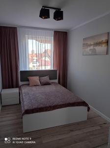 a bedroom with a bed and a window at Apartament Mazury Węgorzewo in Węgorzewo