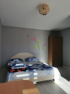 a bedroom with a bed with flowers on the wall at casa la meduza in Vama Veche