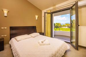 - une chambre avec un grand lit blanc et un balcon dans l'établissement Nostalgia Apartments Zante, à Zante