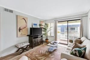 a living room with a couch and a tv at Oceanside 301-A in Isle of Palms