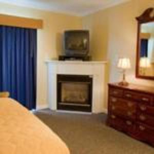 a bedroom with a fireplace with a tv on top of it at InnSeason Resorts Captain's Quarters in Falmouth