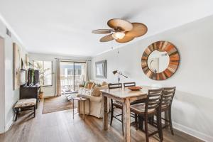 uma sala de estar com uma mesa de jantar e uma ventoinha de tecto em Oceanside 301-A em Isle of Palms