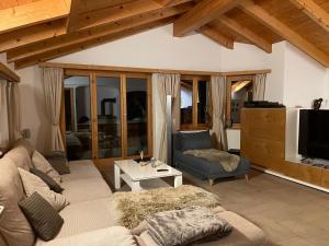 a living room with a couch and a tv at Chalet Casa Sharm in Saas-Fee