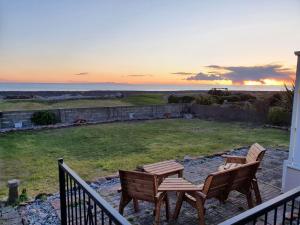 two chairs and a table on a balcony with the ocean at Mona Villa Holiday Home in Caulderton