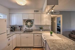a kitchen with white cabinets and a sink at Condo with Balcony - Walk to Lake, Dining, and Shops! in Lake Havasu City