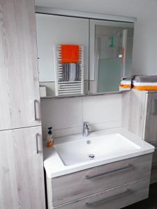 a bathroom with a sink and a mirror at Ferienwohnung Am Damm in Wesel +23 photos