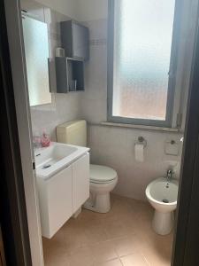 プンタ・マリーナにあるAppartamento Marinaのバスルーム(洗面台、トイレ付)、窓が備わります。