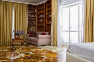 a bedroom with a bed and a couch and a window at Il Giardino Di Flora con Piscina & Jacuzzi in Lecce