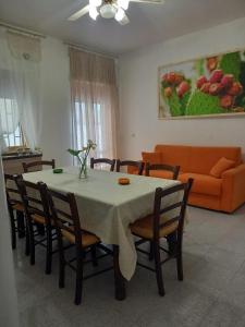 a dining room with a table and chairs and a couch at baia verde appartamento 150 m dal mare in Gallipoli