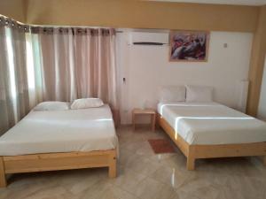 two beds in a small room at IMOBITUR Apartamentos - Palmarejo Baixo in Praia